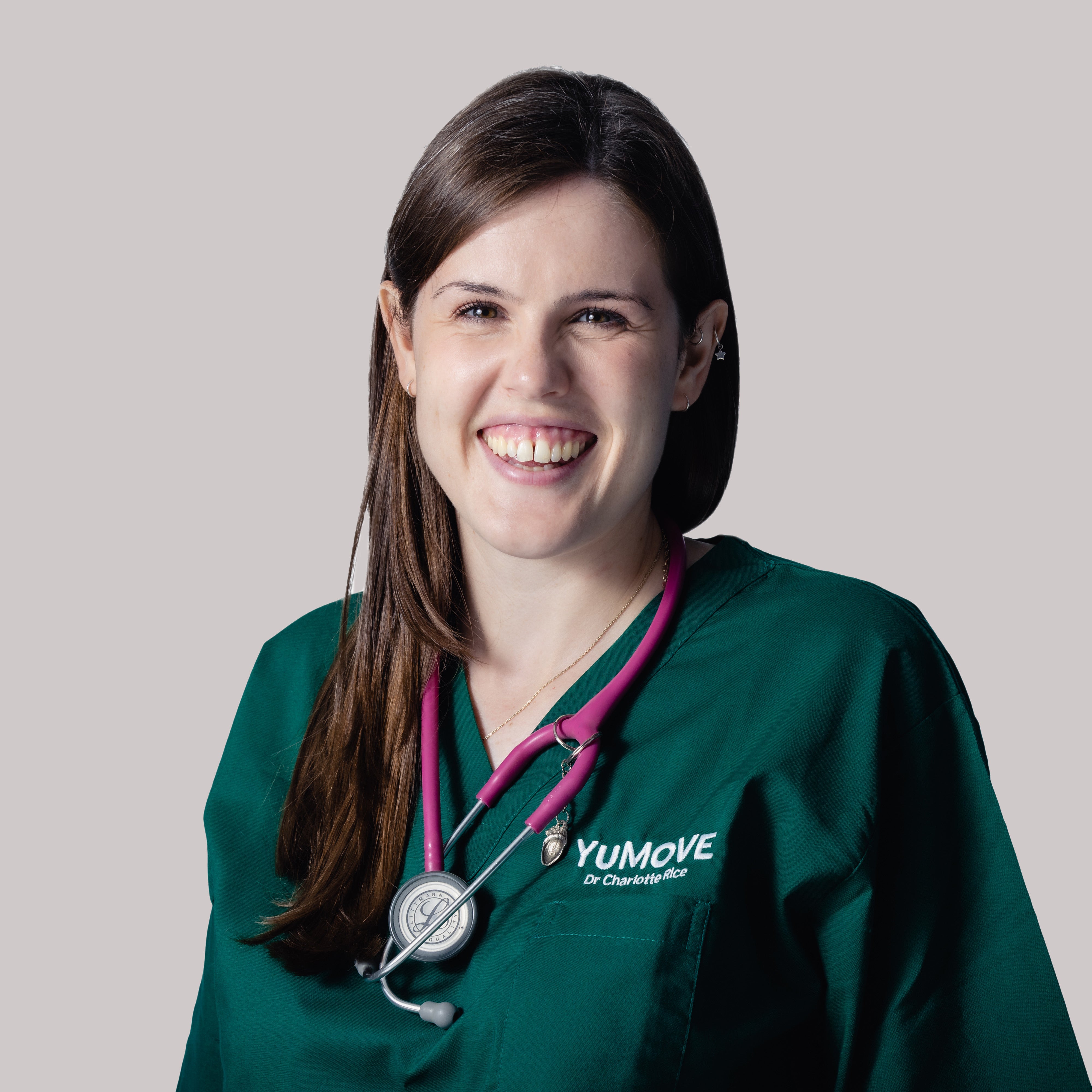 This image is of Dr. Charlotte Rice, Veterinary Technical Manager at YuMOVE, wearing green YuMOVE branded scrubs and a stethoscope in front of a plain white background.
