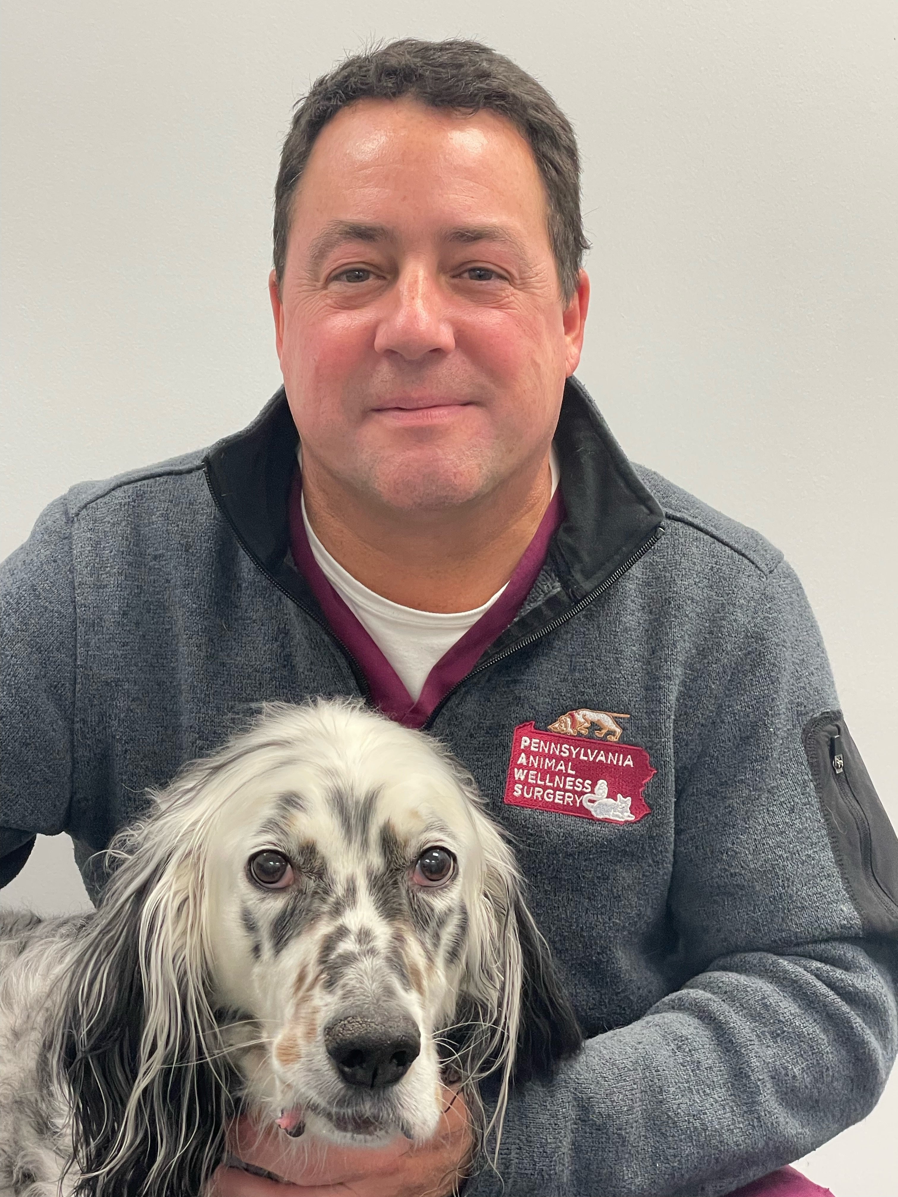 This image is of Dr. Roman Lamberski, DVM and a black and white spotted dog.