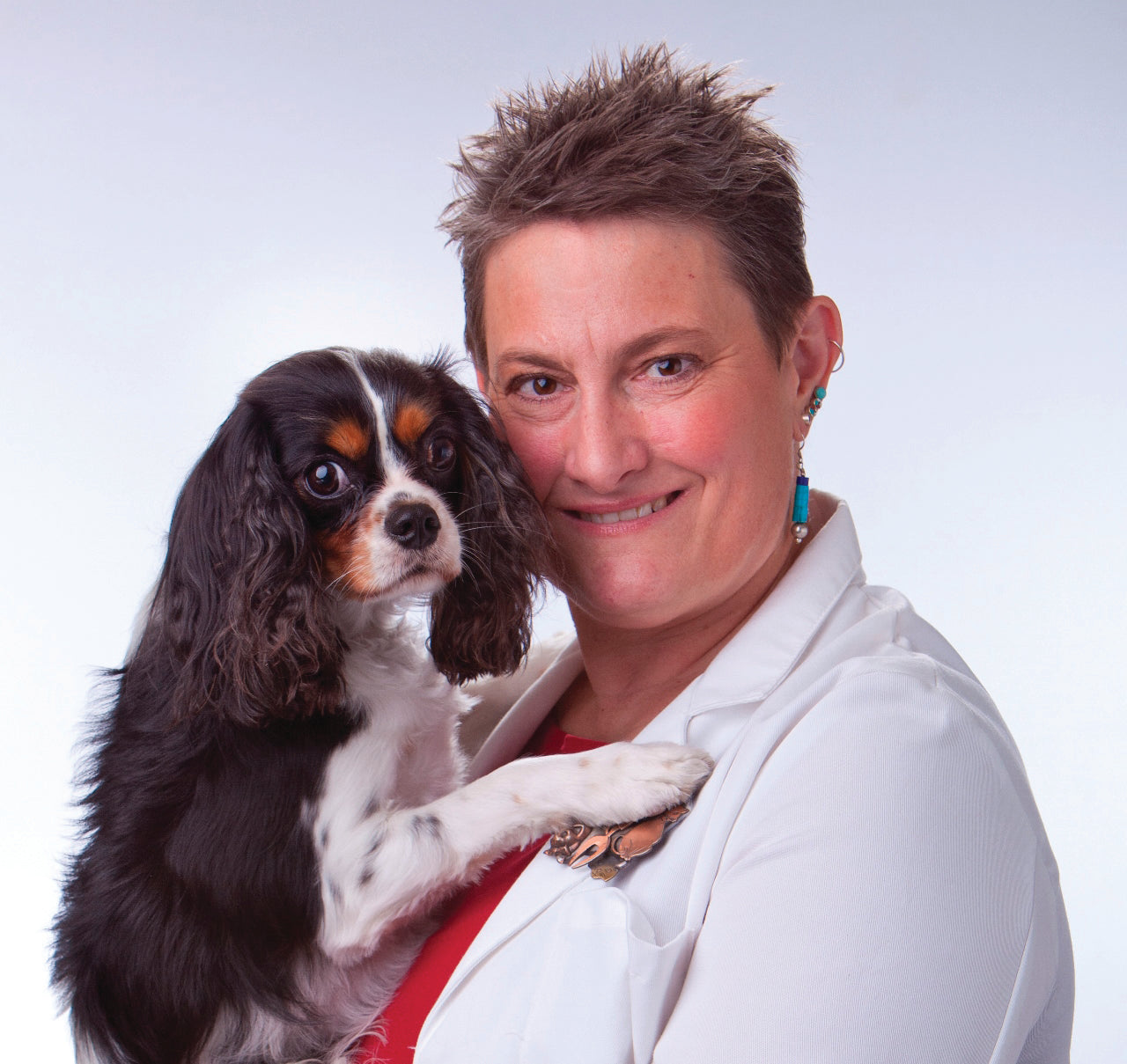 This image is of Dr. Robin Downing and a black, white and tan dog.