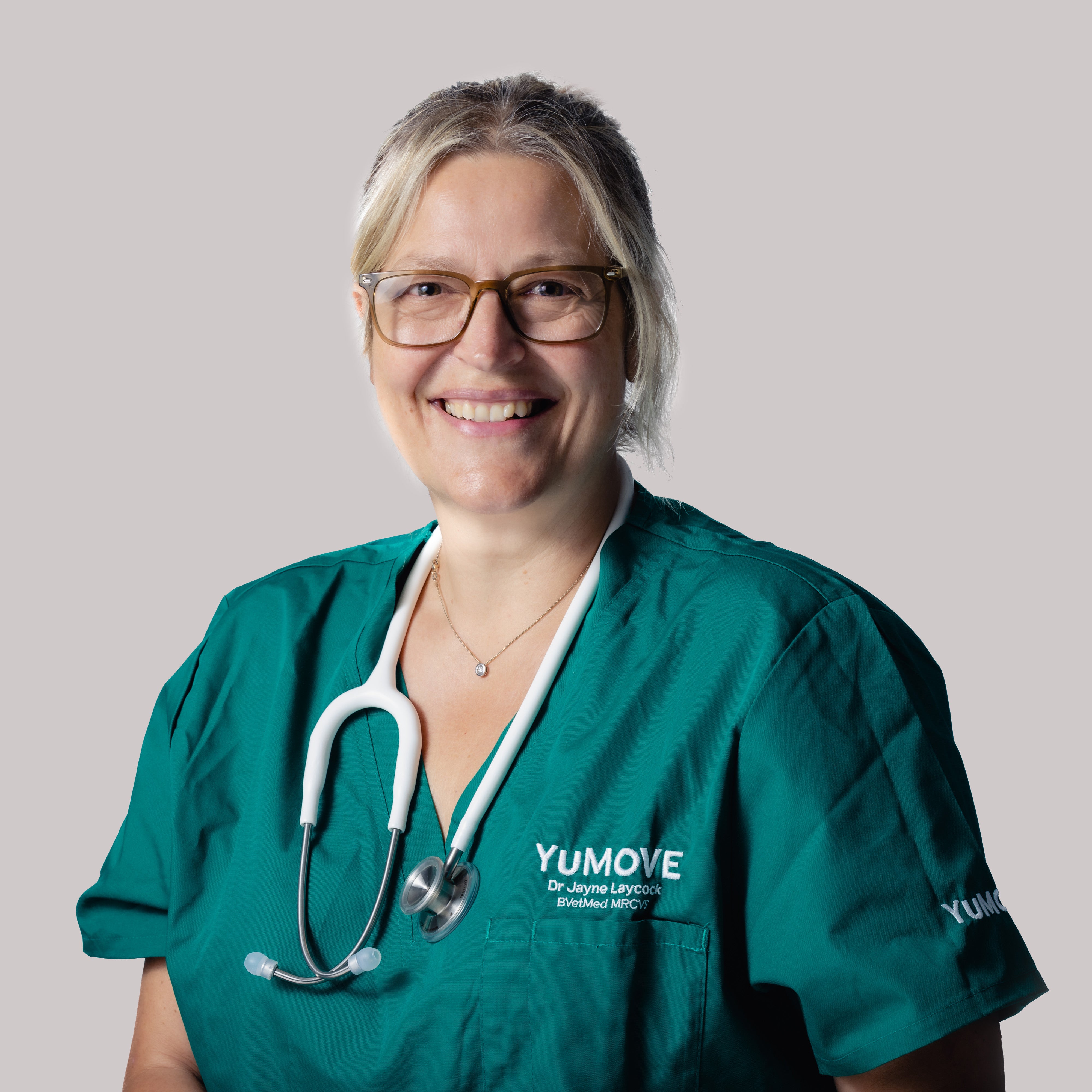 This image is of Dr. Jayne Laycock, Veterinary Technical Lead at YuMOVE, wearing green YuMOVE branded scrubs and a stethoscope in front of a plain white background.