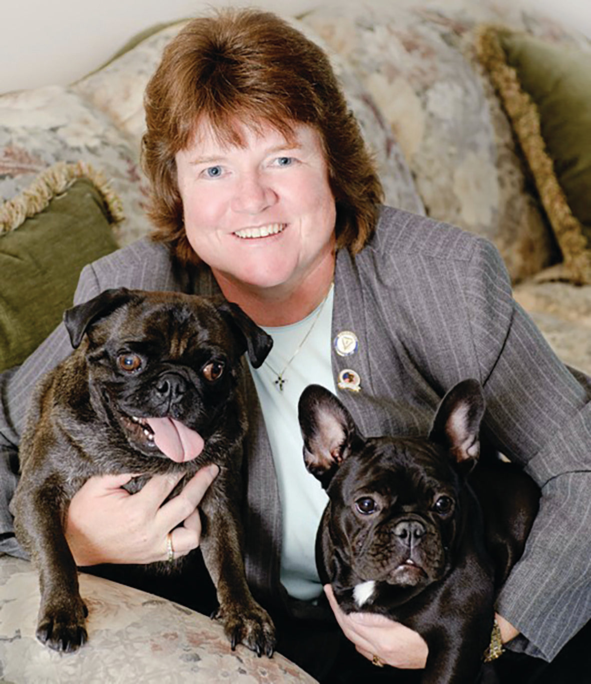 This image is of Kara M. Burns, MS and two black and brown dogs, one with their tongue sticking out.