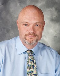 This is an image of Paul McNamara, DVM, in a patterned tie and blue shirt.