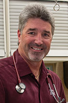 This is an image of George Tabone, DVM, wearing a maroon polo shirt and a stethoscope.